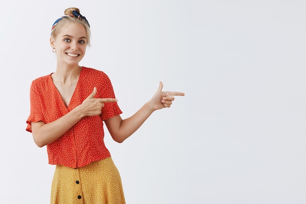 Kostenloses Foto entzückendes junges blondes mädchen, das gegen die weiße wand aufwirft