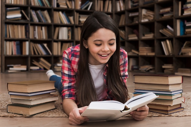 Entzückendes junges Mädchen, das an der Bibliothek studiert