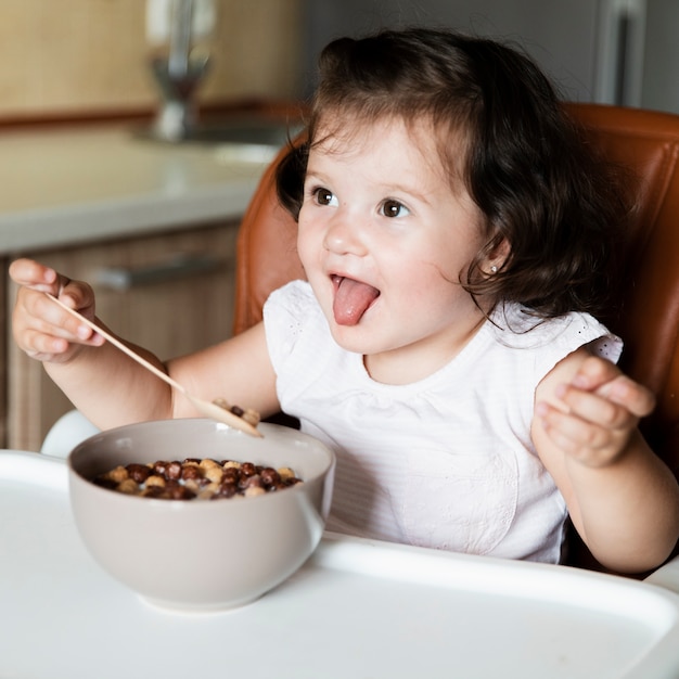 Entzückendes junges Mädchen, das Getreide isst