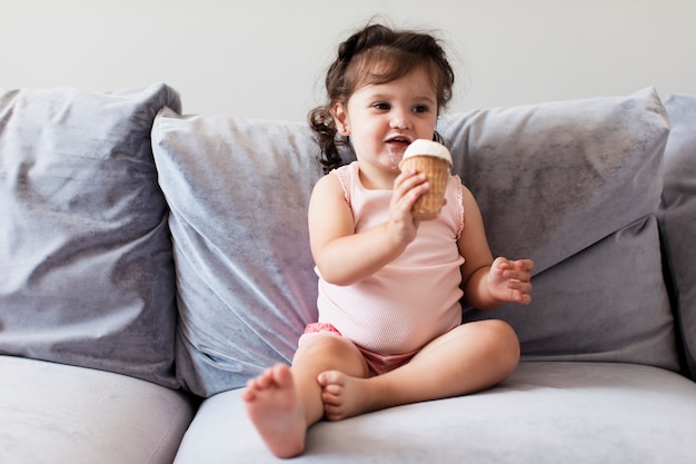 Entzückendes junges Mädchen der Vorderansicht auf dem Sofa