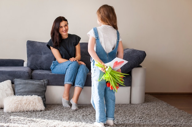 Kostenloses Foto entzückendes junges mädchen überraschen mutter mit geschenken