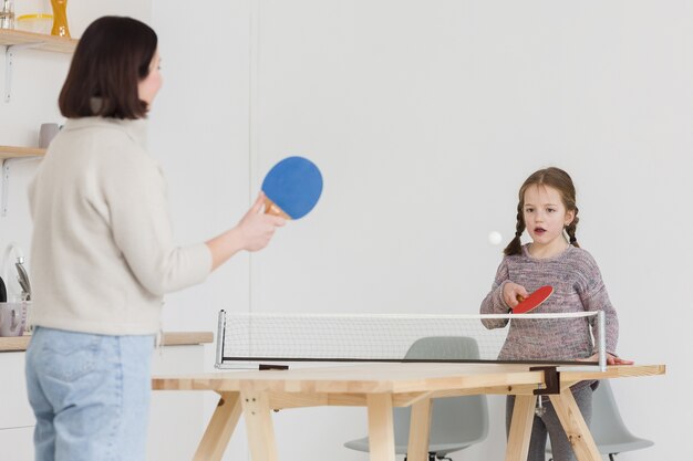 Entzückendes Kind und Mutter, die drinnen spielen