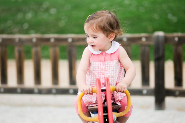 Entzückendes kleines Mädchen, das in einem städtischen Park spielt