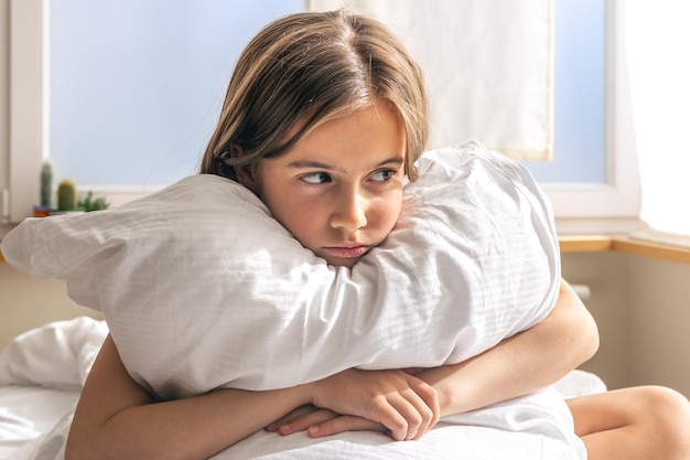 Entzückendes kleines Mädchen in ihrem Bett am frühen Morgen