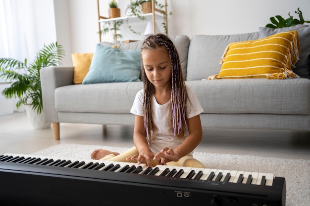 Entzückendes Mädchen, das zu Hause Klavier spielt