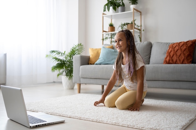 Kostenloses Foto entzückendes mädchen, das zu hause yoga macht