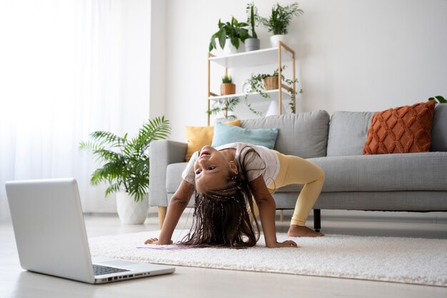 Entzückendes Mädchen, das zu Hause Yoga macht