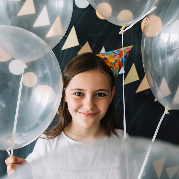 Entzückendes Mädchen mit lichtdurchlässigen Ballonen