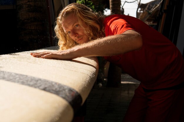 Er Surfer wäscht sein Board mit Wasser. bali