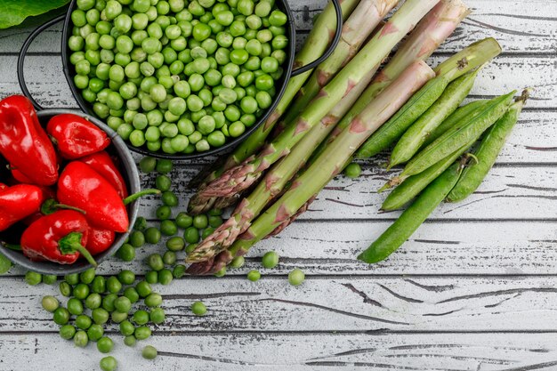 Erbsen in einem Topf mit Paprika, Spargel, grüne Hülsen Draufsicht auf einer Holzwand