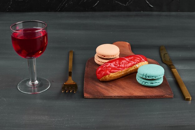 Erdbeer-Eclair mit Macarons und Wein.