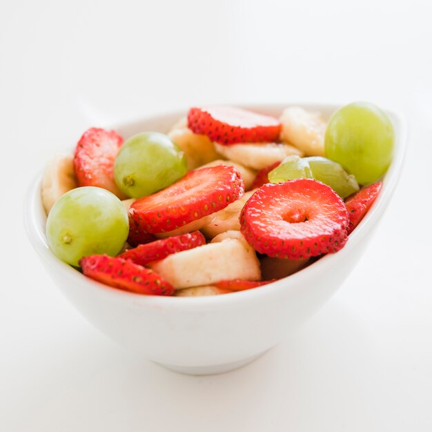 Erdbeer-Scheiben; Banane; Trauben in der Schüssel auf weißem Hintergrund