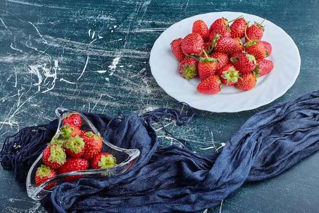 Erdbeeren in einem weißen Teller und in Glasschale.