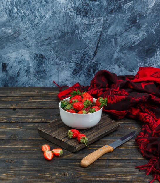 Erdbeeren in einer Schüssel, Messer und rotem Schal