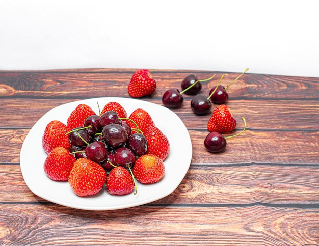 Erdbeeren mit kirschen in einer kleinen glasschüssel Premium Fotos