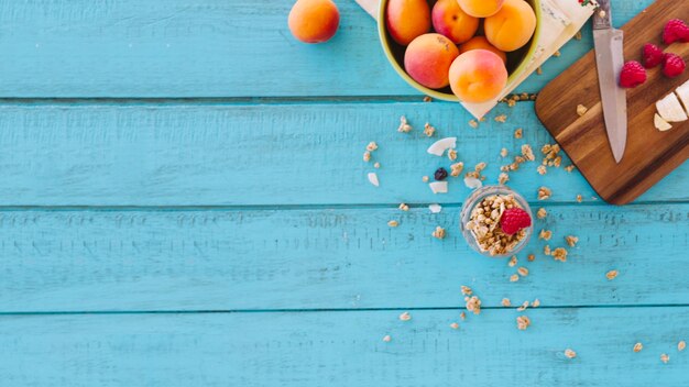 Erdbeeren; Pfirsich und Hafer auf blauer hölzerner Planke