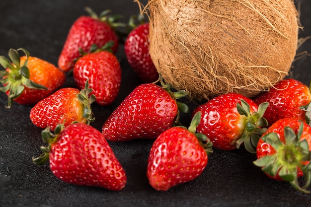Erdbeeren reife milde leckere Kokosnuss lokalisiert auf grauem Boden