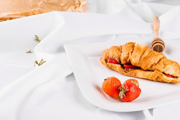 Erdbeeren und Croissant auf Platte