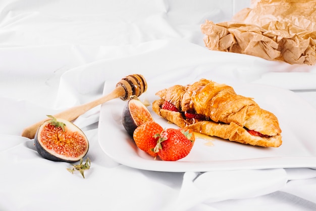 Erdbeeren und Feigen in der Nähe von Croissants