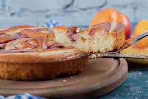 Kostenloses Foto erdbeersirupkuchen mit gelben pfirsichen herum.