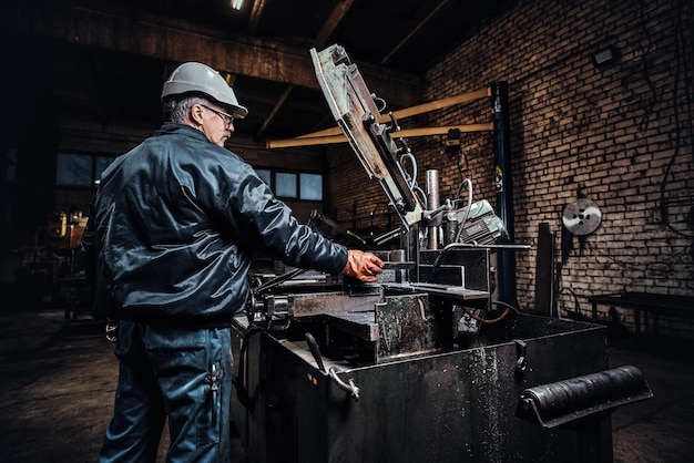 Erfahrene Arbeiter arbeiten in der Metallfabrik mit einer speziellen Werkzeugmaschine.