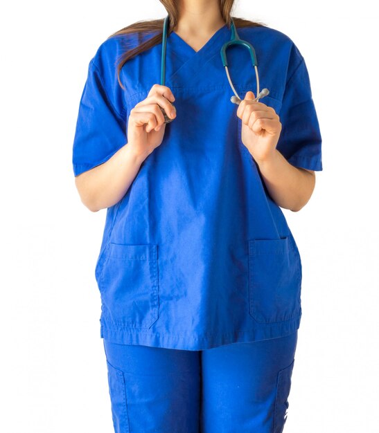 Erfolgreiche junge Ärztin in einer blauen medizinischen Uniform, die ein Stethoskop hält