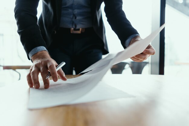 Erfolgreicher Geschäftsmann, der Dokumente in einem modernen Büro signiert