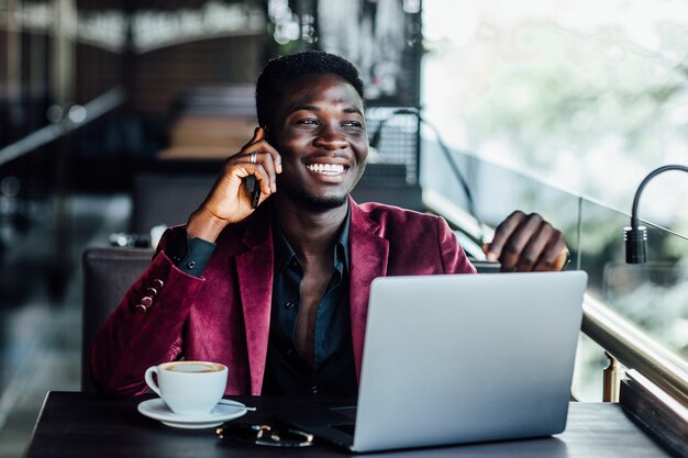 Erfolgreicher männlicher Freiberufler, der sich über Laptop mit WLAN verbindet, nachdenklicher Geschäftsmann arbeitet am Net-Book, während er am Tisch im modernen Café-Interieur sitzt.