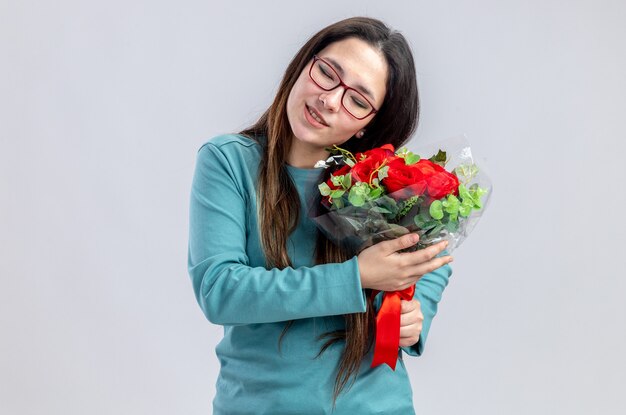 Erfreut mit geschlossenen Augen, die den Kopf kippen, junges Mädchen am Valentinstag, das Blumenstrauß isoliert auf weißem Hintergrund hält