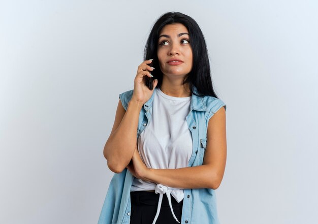 Erfreute junge Kaukasierin spricht am Telefon mit Blick auf die Seite