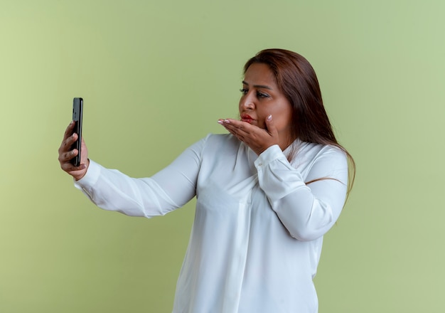 erfreute lässige kaukasische Frau mittleren Alters machen ein Selfie und zeigen Kussgeste