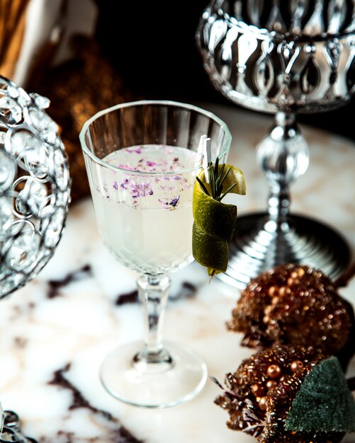 Erfrischender Cocktail mit Limettenschale und Rosmarinzweig