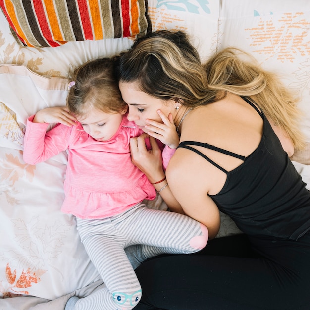 Kostenloses Foto erhöhte ansicht der mutter und der tochter, die auf bett schlafen