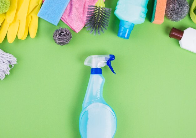 Erhöhte Ansicht der Sprühflasche nahe verschiedenen Reinigungsartikeln