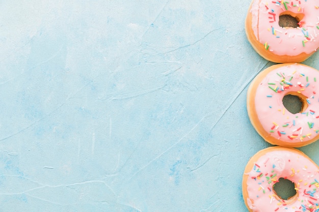 Erhöhte Ansicht von Donuts mit besprüht auf blauem Hintergrund