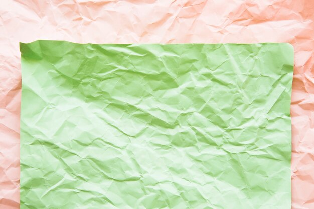 Erhöhte Ansicht von grünen und rosa zerknitterten Papieren