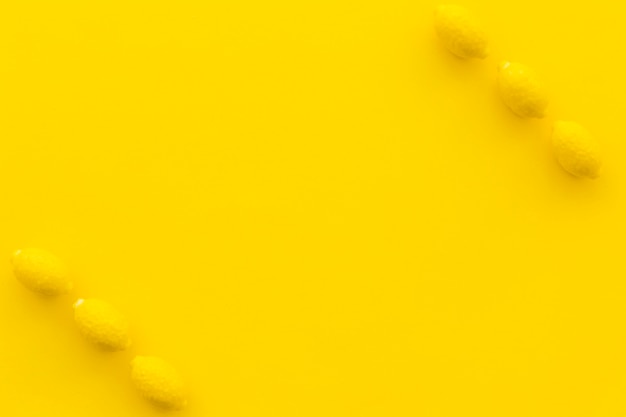Kostenloses Foto erhöhte ansicht von zitronensüßigkeiten auf gelbem hintergrund