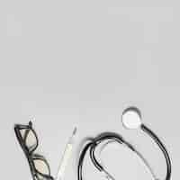 Kostenloses Foto erhöhte sicht von brillen; stethoskop und thermometer auf grauem hintergrund