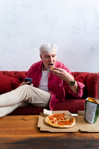 Ermächtigter opa beim pizzaessen und entspannen Premium Fotos