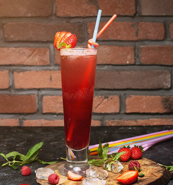 Erneuerndes gesundes Getränk des Sommers, Erdbeeresmoothie oder frisch mit Minze auf einem hölzernen, dunklen, Ziegelstein