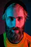 Kostenloses Foto ernst, nahaufnahme. porträt des kaukasischen mannes auf gradientenraum im neonlicht