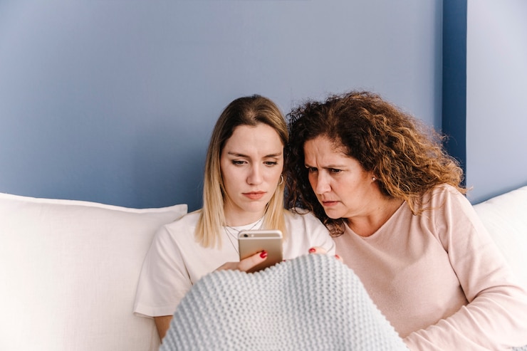 Kostenlose Foto ernste frauen, die smartphone auf sofa verwenden