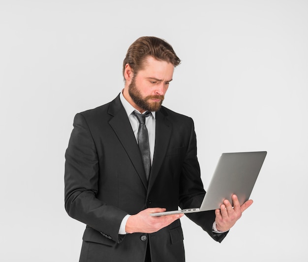 Ernster Geschäftsmann unter Verwendung des Laptops