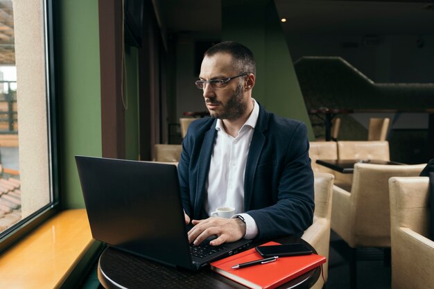 Ernster Mann, der Laptop verwendet