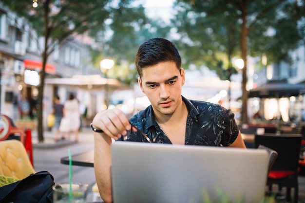 Kostenloses Foto ernster mann, der laptopbildschirm betrachtet