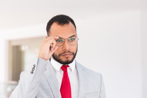 Ernster Wirtschaftsführer, der für Kamera in der Bürohalle aufwirft