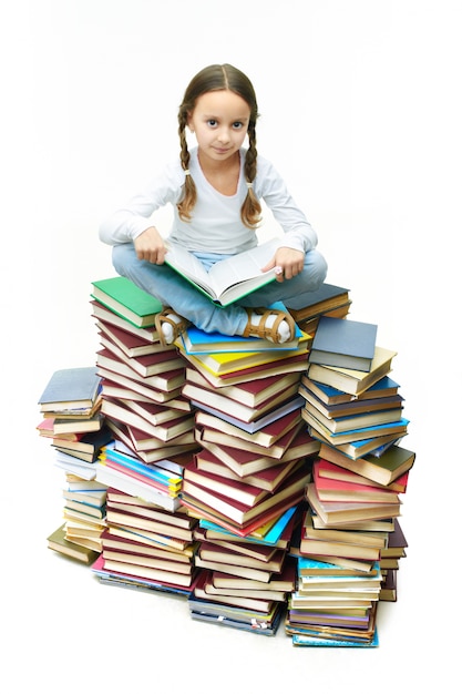 Ernstes kleines Mädchen mit einem offenen Buch auf dem Schoß