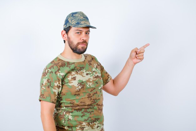 Ernsthaft zeigt der Soldat mit dem Zeigefinger auf weißem Untergrund nach rechts