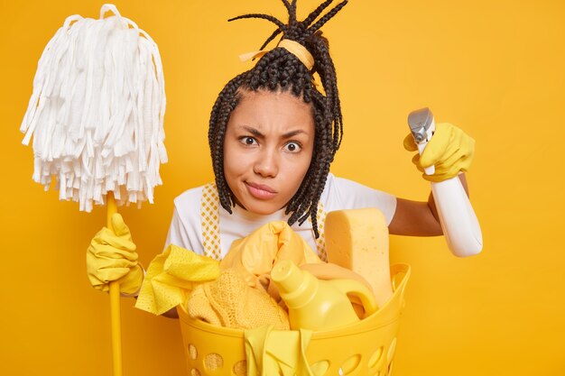 Ernsthafte afroamerikanische Hausfrau mit Zöpfen sieht aufmerksam aus