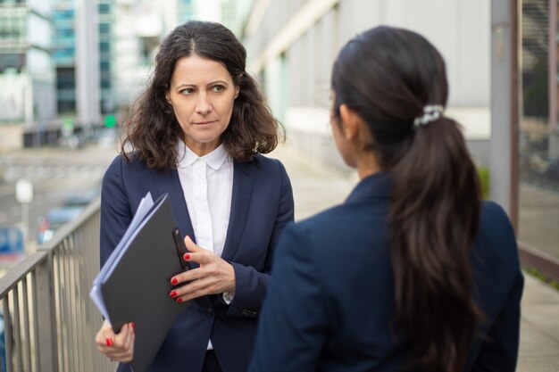 Ernsthafte Geschäftsfrauen diskutieren über Arbeit